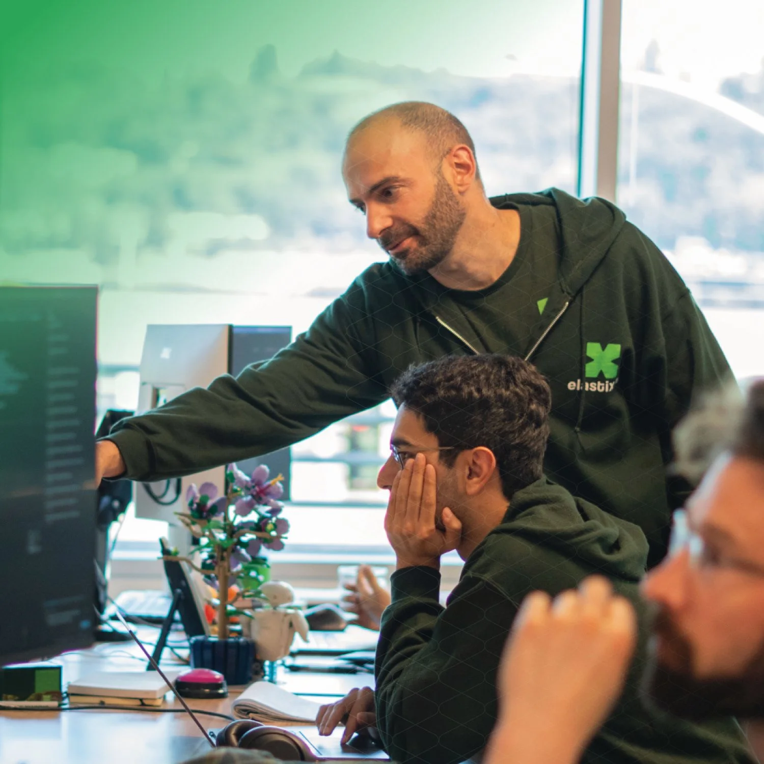 A group of colleagues standing and smiling during a meeting in an office.